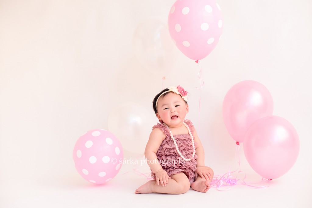 one year old baby girl with pink balloons photographed by San Francisco Bay Area photographer Sarka Photography