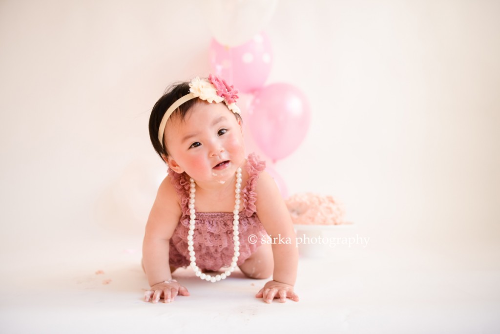 one year old baby girl with a cake and balloons photographed by San Francisco Bay Area photographer Sarka Photography