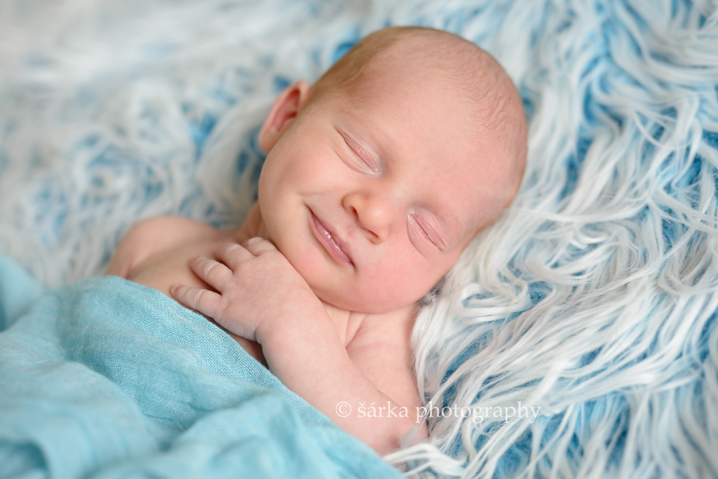 newborn boy sleeping and smiling photographed by San Francisco Bay Area newborn and baby photographer Sarka Photography