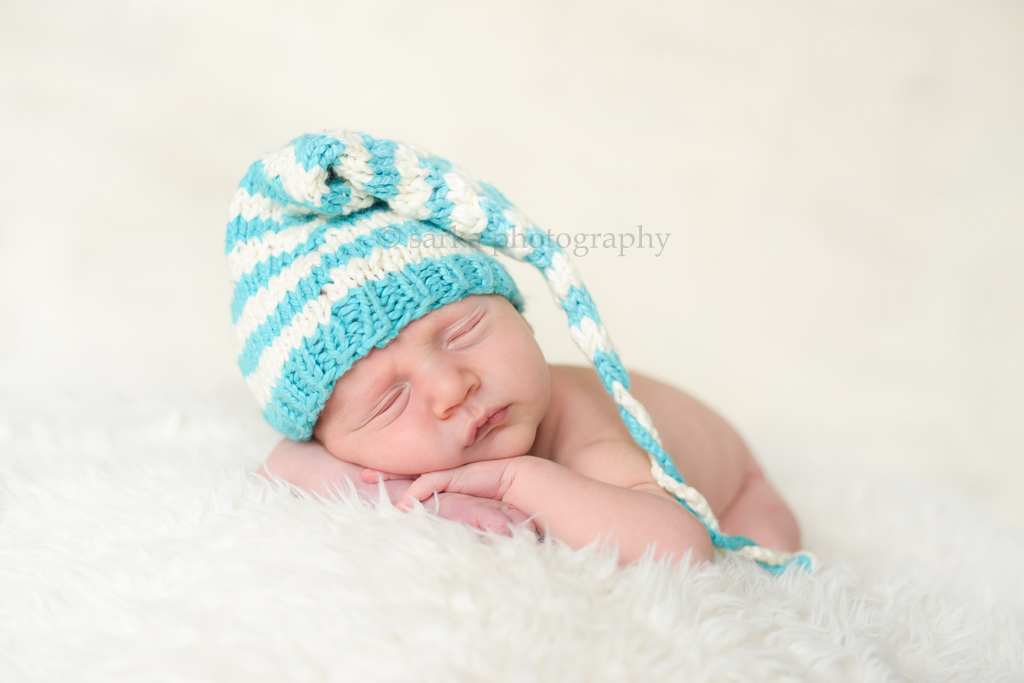 newborn boy sleeping in a knitted striped hat photographed by San Francisco Bay Area newborn and baby photographer Sarka Photography