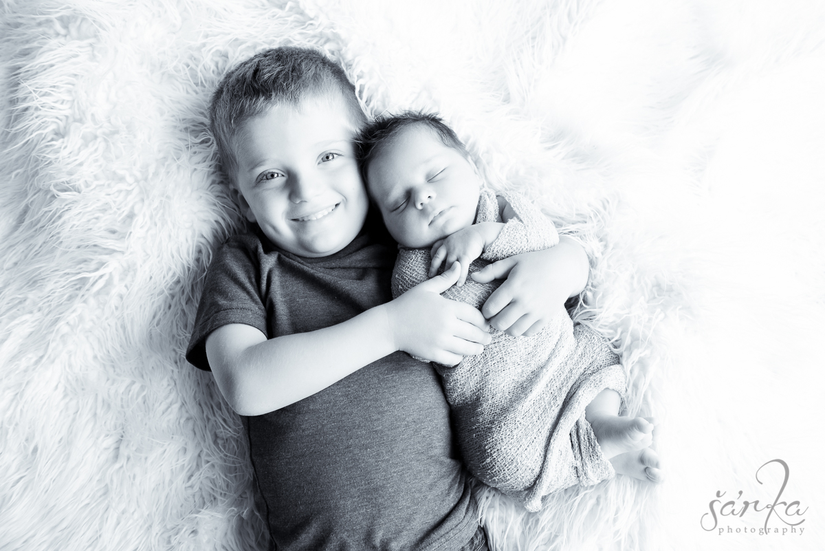 newborn baby girl in his brother's arm photographed by San Francisco Bay Area newborn and baby photographer Sarka Photography