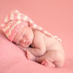 newborn baby girl sleeping in a hand knitted pink hat photographed by San Francisco Bay Area and Santa Barbara baby photographer Sarka Photography