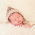 newborn baby girl sleeping in a hand knitted neutral brown colored hat photographed by San Francisco Bay Area and Santa Barbara baby photographer Sarka Photography