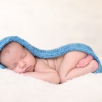 newborn baby boy sleeping in a hand knitted blue wrap photographed by San Francisco Bay Area and Santa Barbara baby photographer Sarka Photography