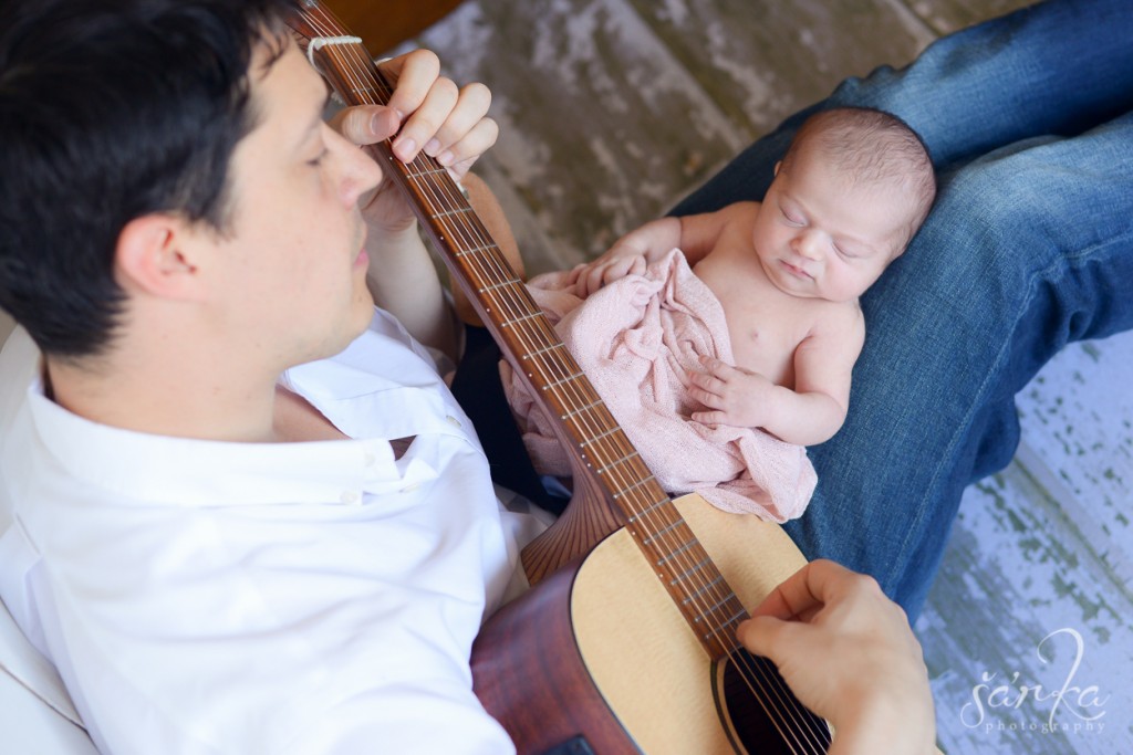 young dad playing a guitar for his newborn baby girl photographed by San Francisco Bay area baby photographer Sarka photogoraphy