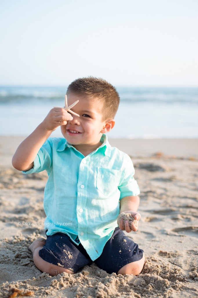 toddler boy holding a star fish on the beach photographed by Santa Barbara children photographer Sarka Photography
