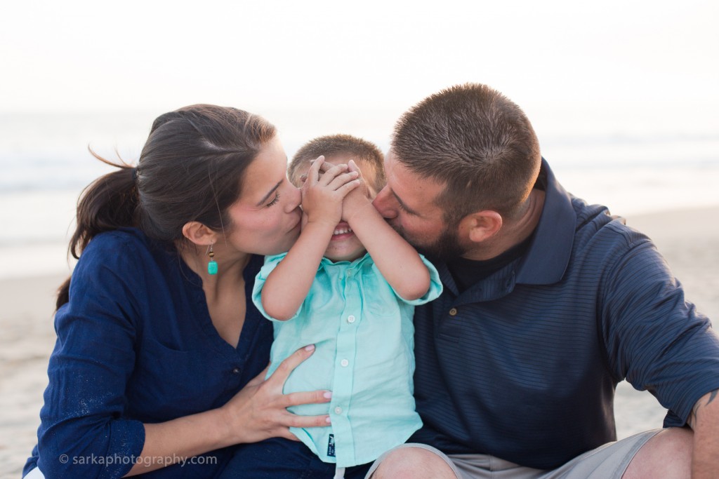 young parents kissing their sun on the beach photographed by Santa Barbara children photographer Sarka Photography