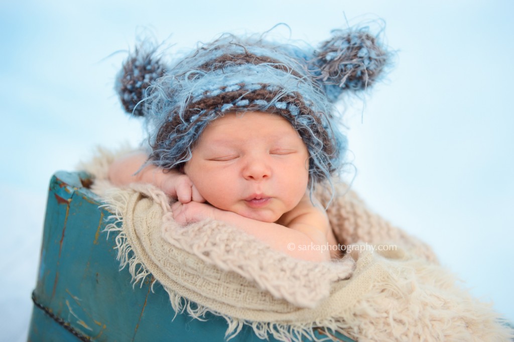 newborn baby boy sleeping in a vintage bucket in a hand knitted hat photographed by San Francisco and Santa Barbara baby photographer Sarka Photography