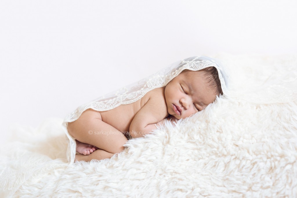 newborn baby girl sleeping under a lace fabric photographed by San Francisco and Santa Barbara baby photographer Sarka photography
