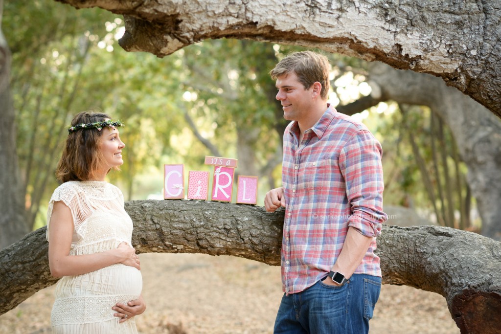young couple with a its a girl sign photographed by Santa Barbara maternity photographer Sarka Photography 