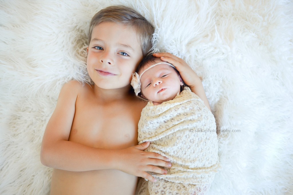 older brother holding his newborn baby sister photographed by Santa Barbara newborn photographer Sarka photography