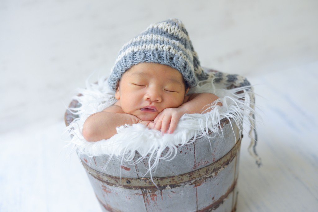 newborn baby boy sleeping in a vintage wooden bucket photographed by San Francisco East Bay Area baby photographer Sarka Photography
