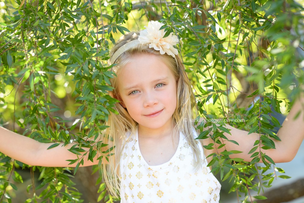 young girl peeking through a pepper tree photographed by Bay Area family photographer Sarka Photography