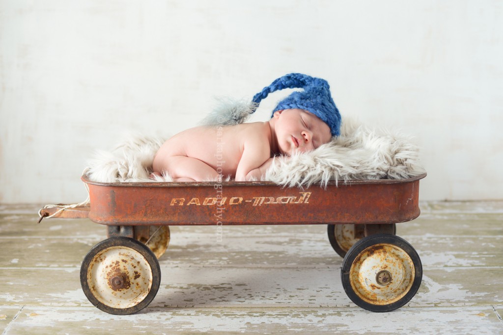 newborn baby boy sleeping in a vintage wagon by Marin baby photographer Sarka Photography