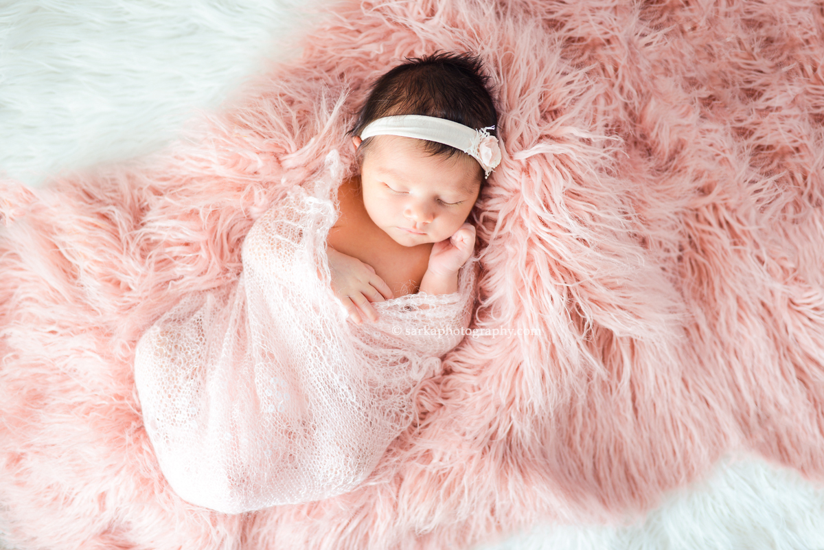 newborn baby girl swaddled in a pink hand knitted wrap photographed by Santa Barbara and San Jose Baby photographer Sarka Photography