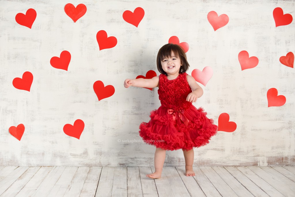 toddler girl in a red chiffon dress surrounded by hearts for Valentine's day photographed by Santa Barbara baby and children photographer Sarka photography