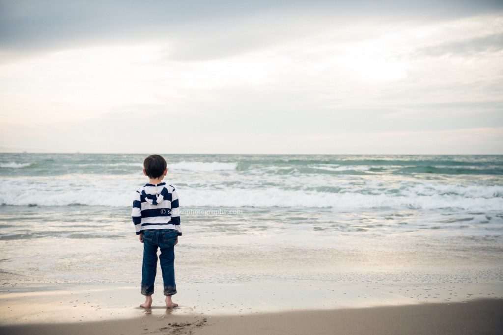 little boy looking out at the ocean during sunset photographed by Santa Barbara children and family photographer by Sarka Photography