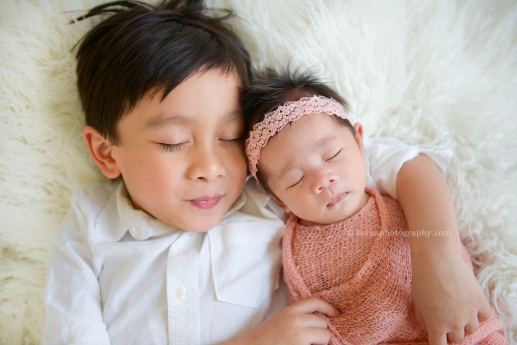 newborn baby girl sleeping in her older brothers arms photographed by Santa Barbara and San Francisco Bay area photographer Sarka