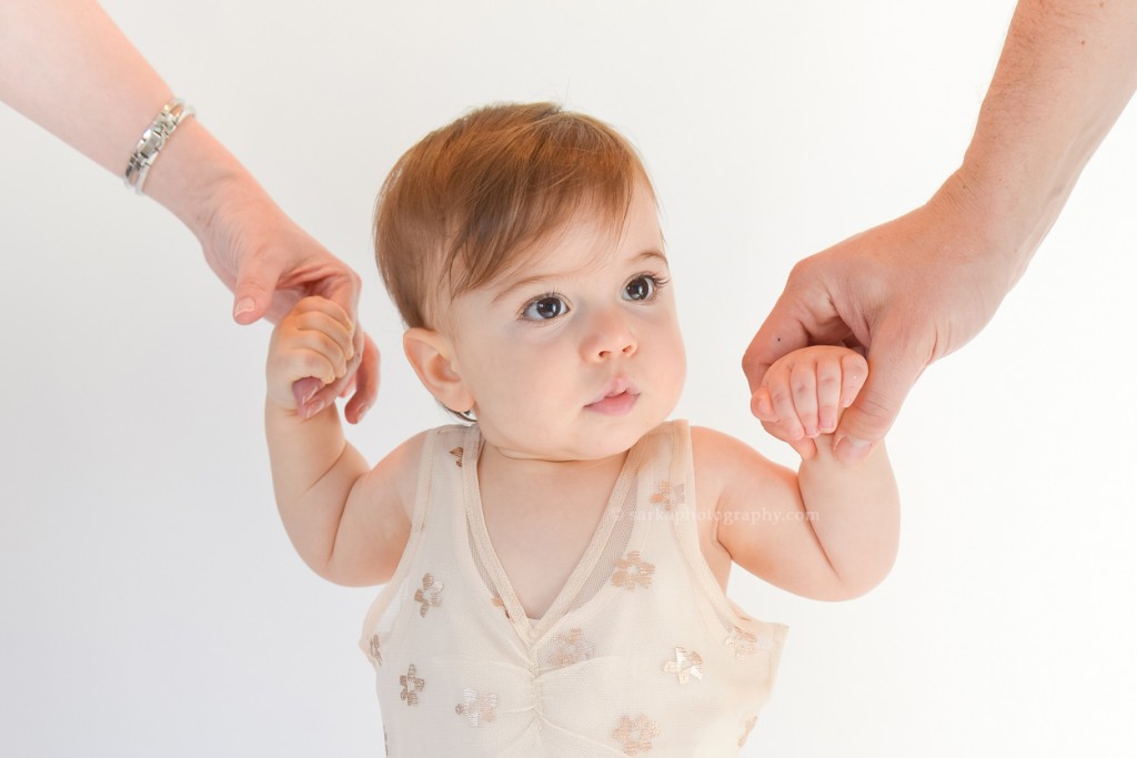 one year baby girl holding her parents hands photographed by San Francisco and Santa Barbara baby photographer Sarka