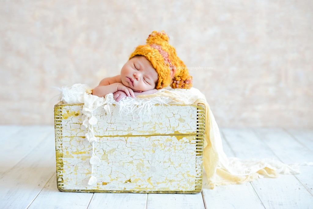newborn baby girl sleeping in a rustic wooden box wearing a hand knitted hat photo by Santa Barbara Thousand Oaks Malibu baby newborn and family photographer Sarka photography