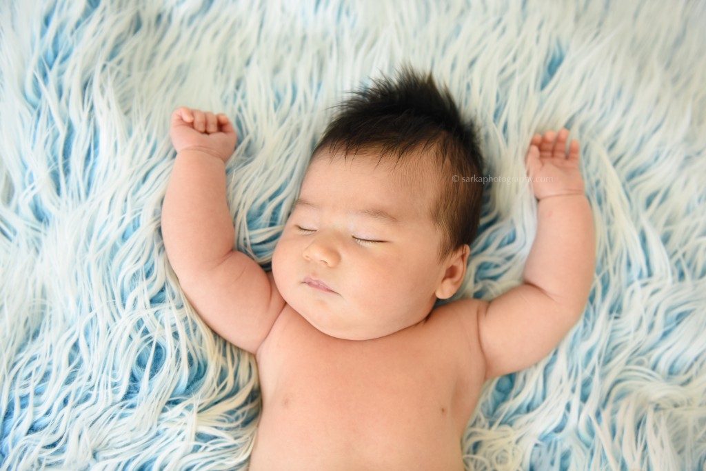 baby boy sleeping on a fuzzy blanket with arms up baby boy in a wooden box photographed by Santa Barbara and Burlingame baby photographer Sarka Photography