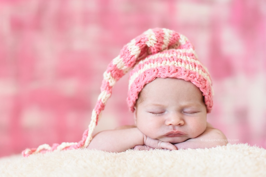 newborn baby girl sleeping wearing a hand knitted striped hat photographed by Santa Barbara Montecito newborn and baby photographer Sarka photography
