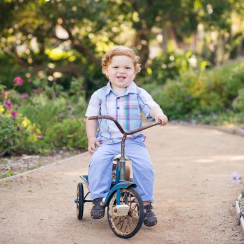 toddler boy sitting on a vintage tricycle during his custom children photo session in Santa Barbara by sarkaphotography