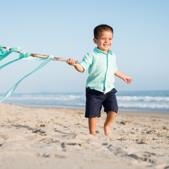 toddler boy running on a beach during his child portrait lifestyle photo session in Carpinteria by Santa Barbara children and family photographer sarkaphotography