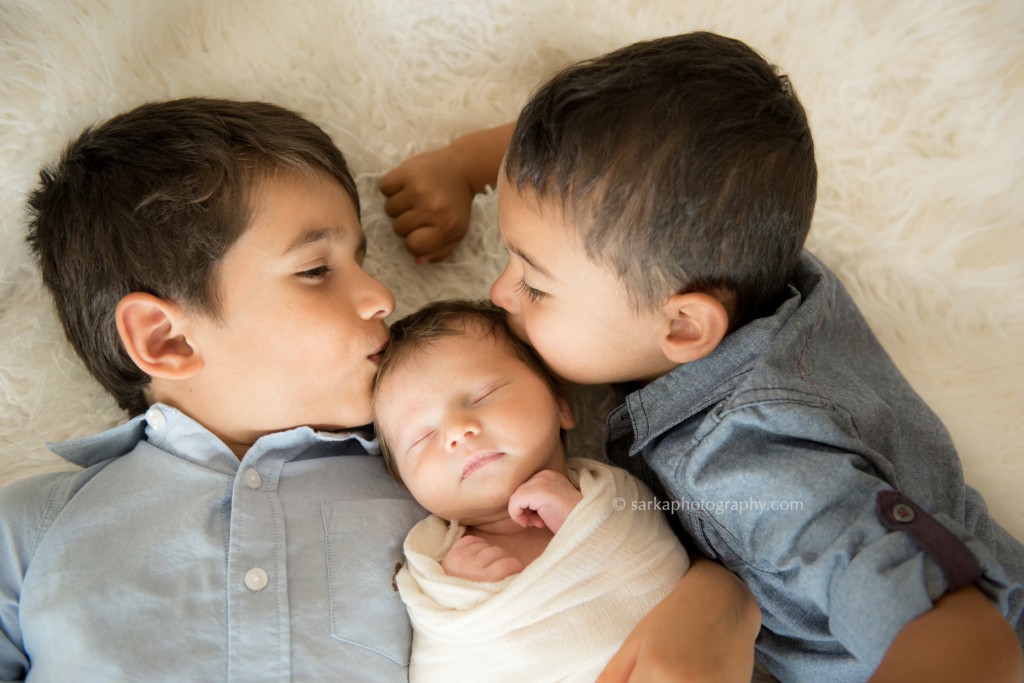 sibling boys kissing their newborn brother by Sarka photography