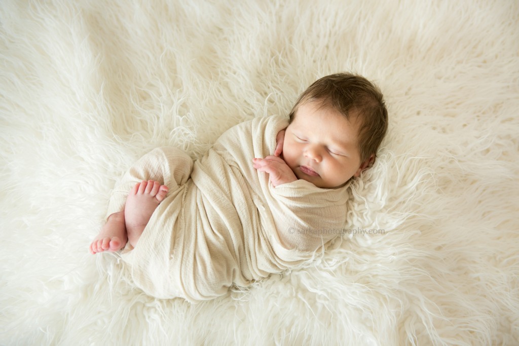 newborn sleeping on a furry blanket photographed by santa barbara based baby photographer sarka
