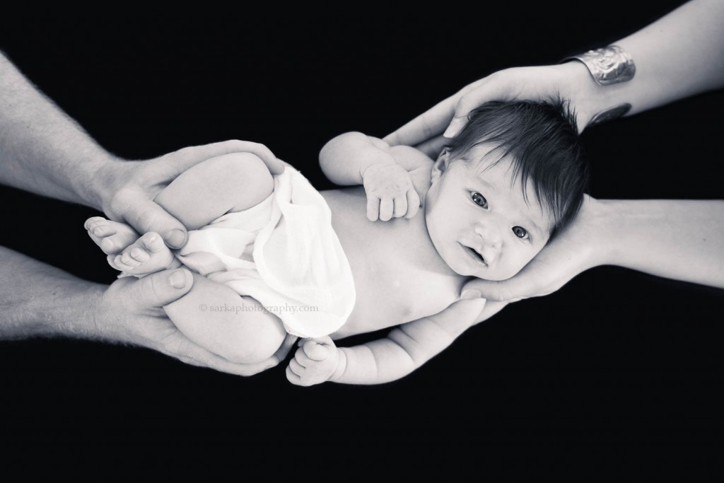 black and white portrait of new parents holding their newborn baby girl in their hands photographed by Santa Barbara Carpinteria Montecito newborn photographer Sarka Photography