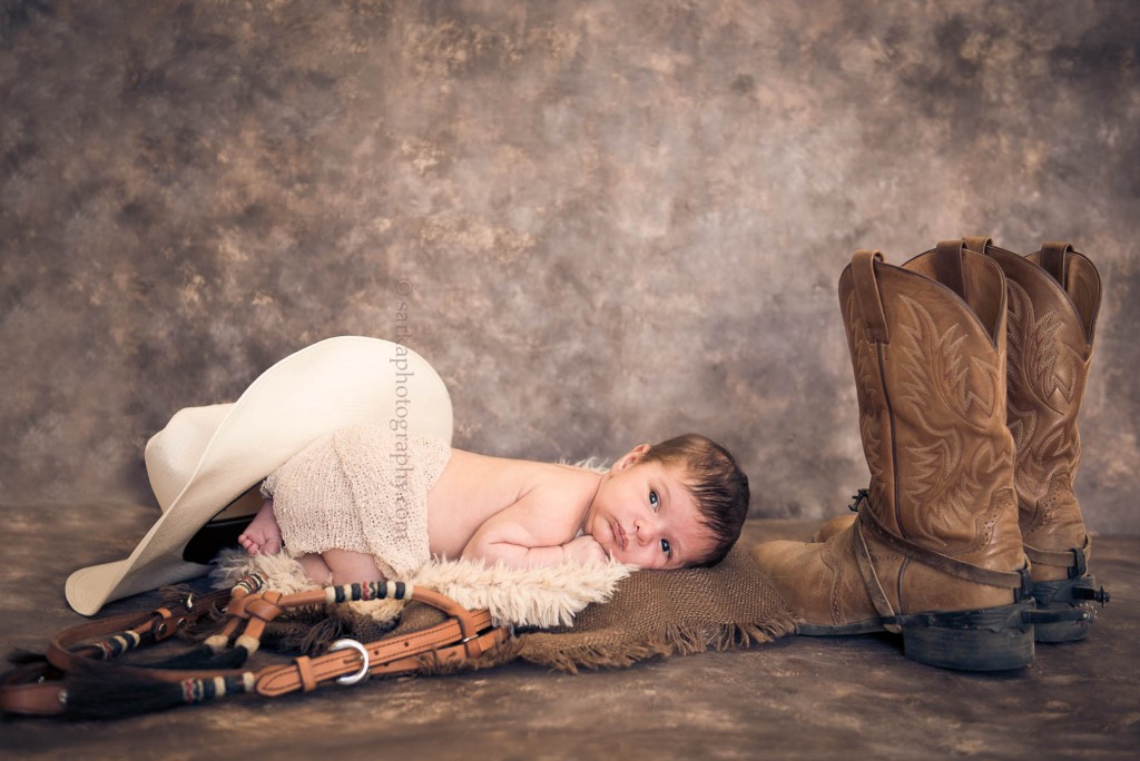 newborn baby boy with equestrian props photographed by Santa Barbara Ojai baby photographer sarkaphotography