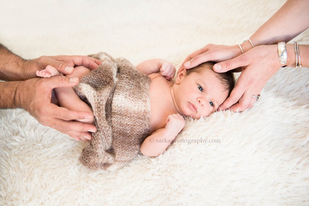 newborn baby boy in his parents hands photographed by Santa Barbara Ojai baby photographer sarkaphotography