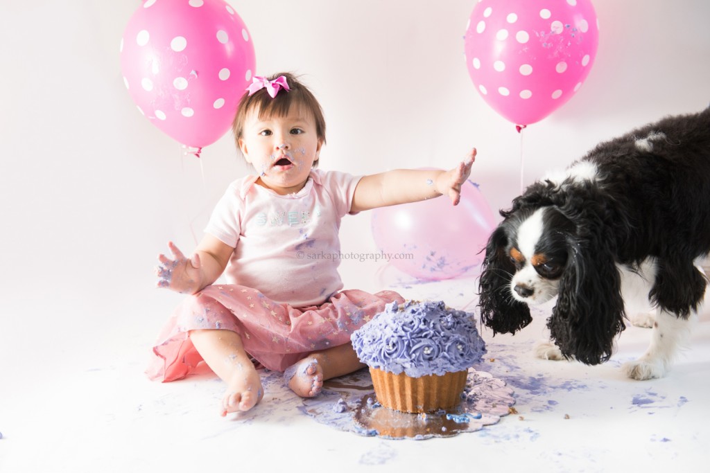 one your old baby girl and her dog during cake smash photo session by San Jose, Bay area and Santa Barbara baby photographer sarkaphotography