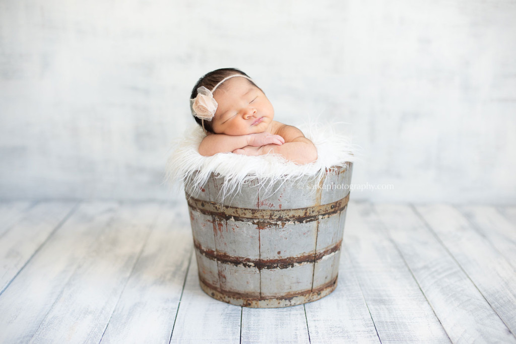 newborn baby girl in a vintage bucket