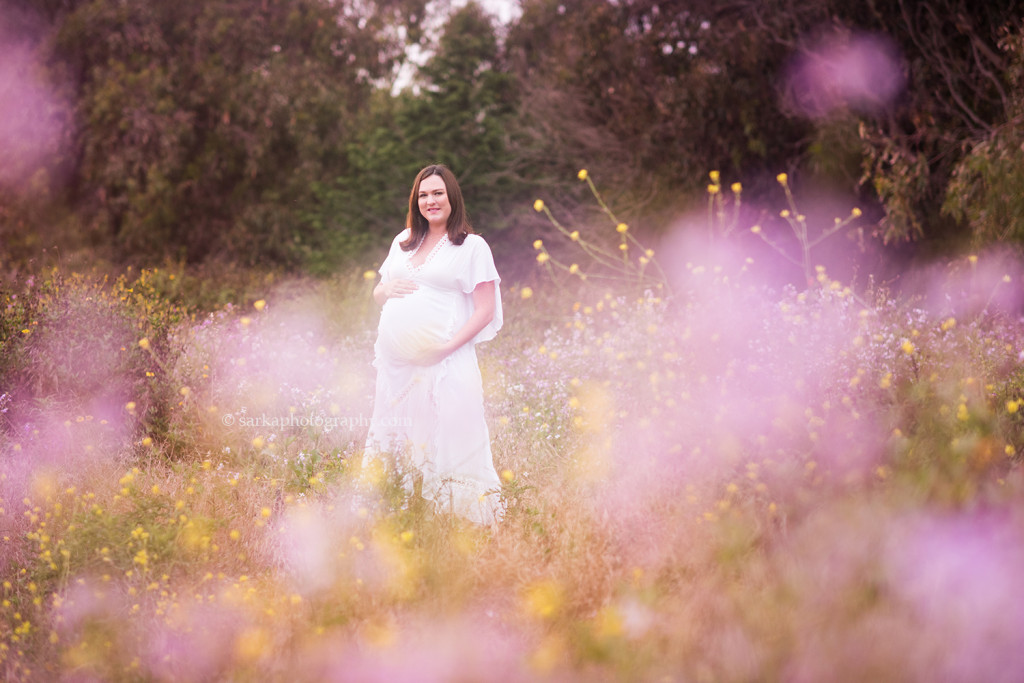 dreamy pregnancy portrait of a new expecting mom in a spring flower field near Santa Barbara