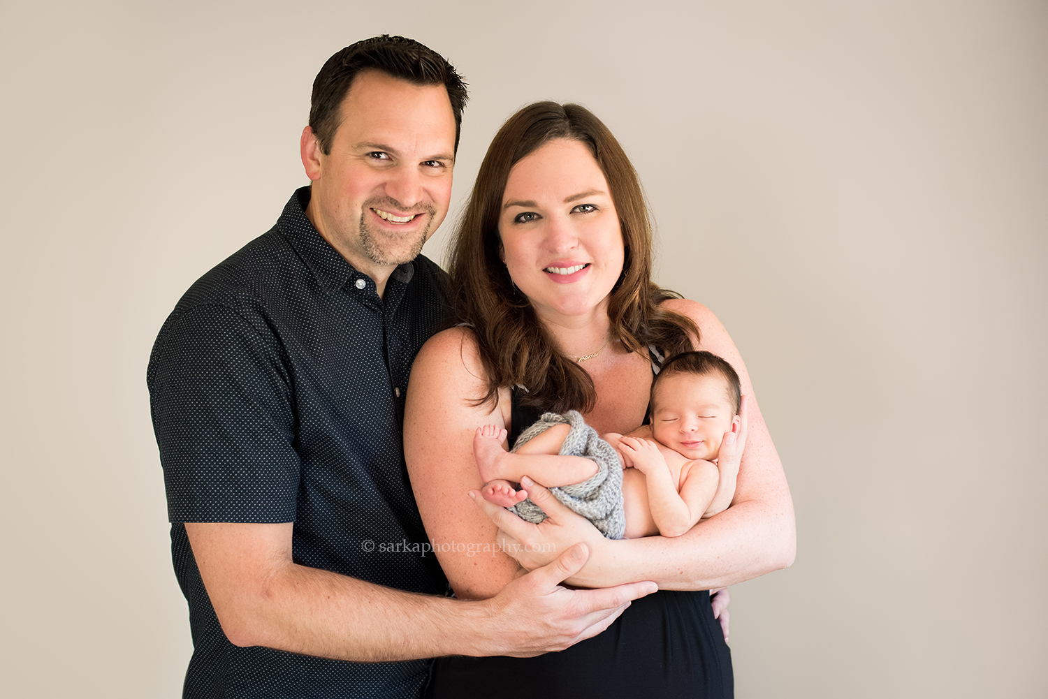young parents holding their newborn boy during family photo session in Santa Barbara
