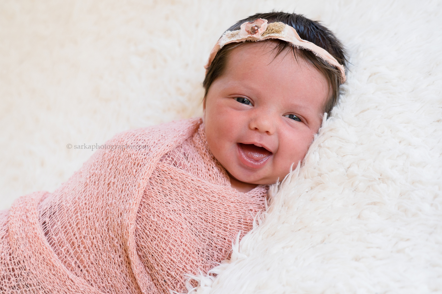 newborn baby girl smiling during her baby portrait session in Santa Barbara county