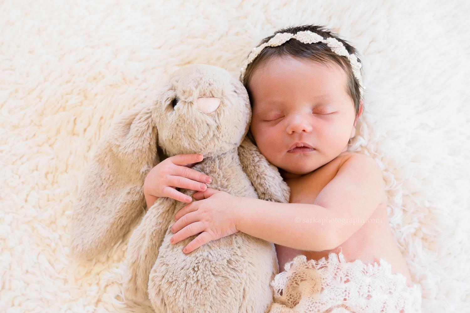 newborn baby girl snuggling a stuffed animal bunny during her baby photo session in Santa Barbara