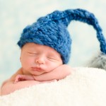 newborn baby boy sleeping in a hand knitted blue hat photographed by San Francisco Bay Area and Santa Barbara baby photographer Sarka Photography