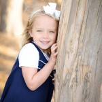 little girl smiling by a tree photographed by Santa Barbara and San Francisco Bay area photographer Sarka Photography