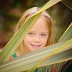 little girl peaking through leaves photographed by Santa Barbara and San Francisco Bay area photographer Sarka Photography