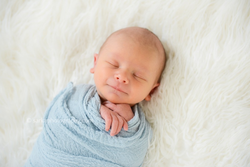 newborn baby boy smiling while sleeping photographed by San Francisco and Santa Barbara baby photographer Sarka Photography