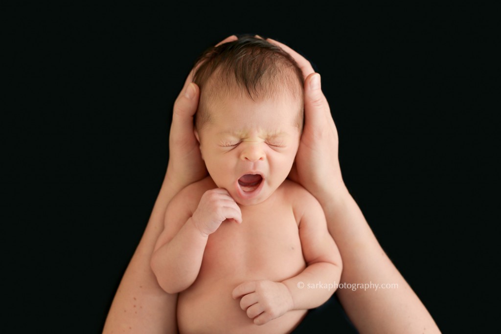 newborn baby yawning in her moms hands photographed by San Francisco Bay area and Santa Barbara baby photographer Sarka Photography