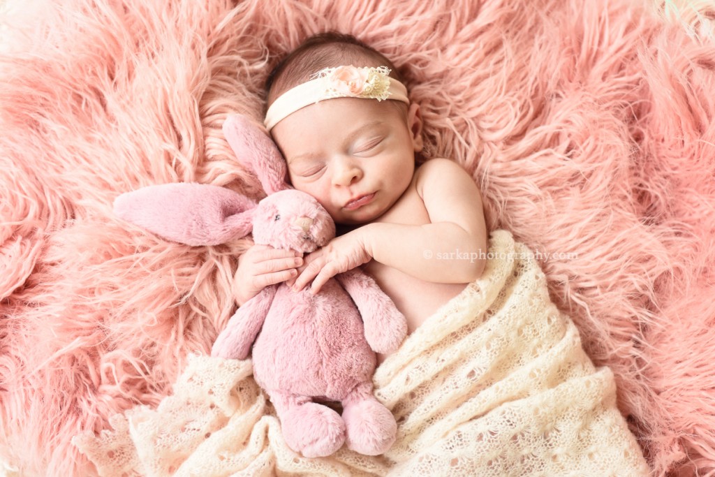 newborn baby girl sleeping and holding a stuffed animal pink bunny photographed by San Francisco and Santa Barbara newborn baby photographer Sarka photography