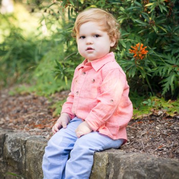 toddler boy sitting on a stone ledge during his children photo session in Santa Barbara by sarkaphotography